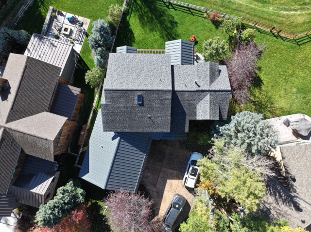 Aerial view of a home with shingle and metal roofing